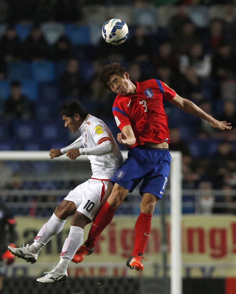 South Korea's Koo Ja-cheol, right, fights for the ball with Myanmar's Kyaw Ko Ko during their Asian zone Group G qualifying soccer match for the 2018 FIFA World Cup at Suwon World Cup Stadium in Suwon, South Korea, Thursday, Nov. 12, 2015. South Korea defeated Myanmar 4-0. (AP Photo/Lee Jin-man)