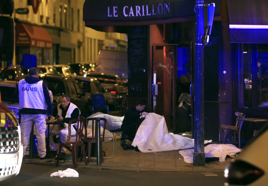 Victims lay on the pavement outside a Paris restaurant, Friday, Nov. 13, 2015. Police officials in France on Friday report multiple terror incidents, leaving many dead. It was unclear at this stage if the events are linked. (AP Photo/Thibault Camus)