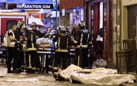 Rescue workers gather at victims in the 10th district of Paris, Friday, Nov. 13, 2015. Several dozen people were killed in a series of unprecedented attacks around Paris on Friday, French President Francois Hollande said, announcing that he was closing the country's borders and declaring a state of emergency. (AP Photo/Jacques Brinon)