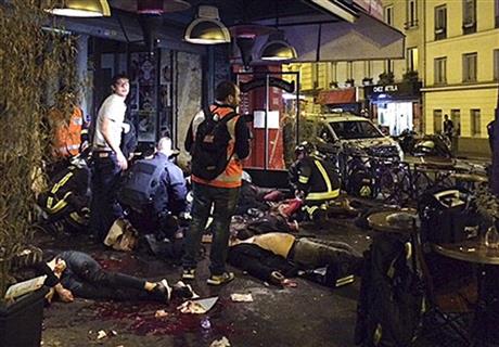 Victims of a shooting attack lay on the pavement outside La Belle Equipe restaurant in Paris Friday, Nov. 13, 2015. Well over 100 people were killed in Paris on Friday night in a series of shooting, explosions. (Anne Sophie Chaisemartin via AP)