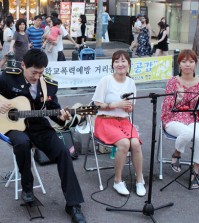 Police lieutenant Song Jun-han plays the guitar on a street near Hongik University, Seoul. (Yonhap)