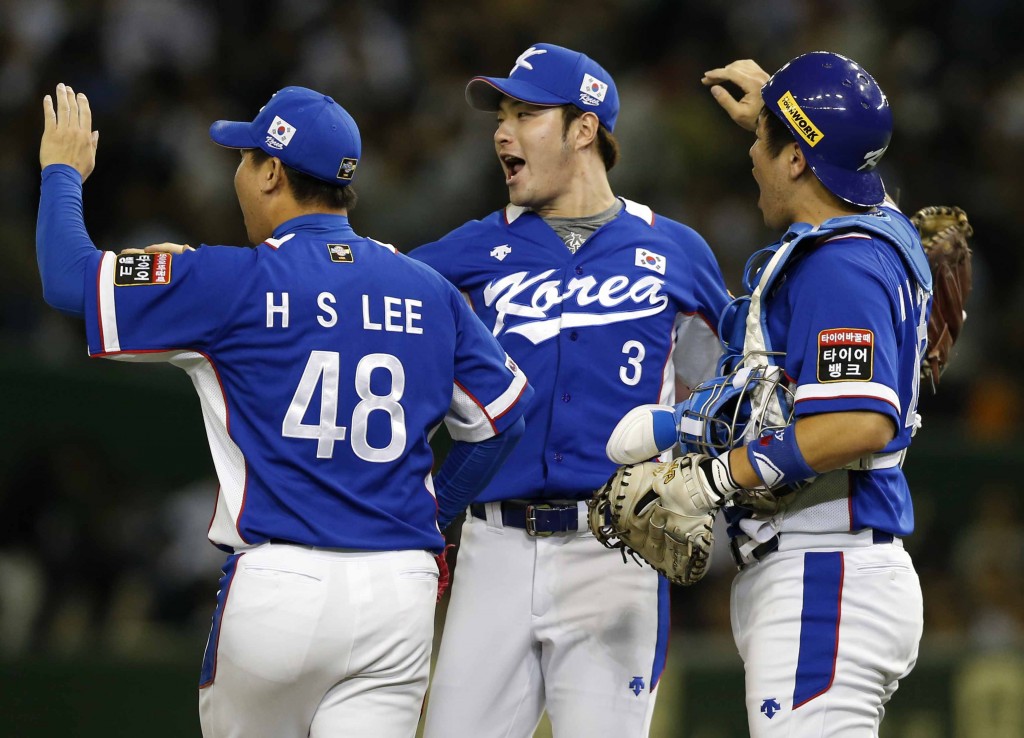 South Korea's closer Lee Hyun-seung (48), first baseman Park Byung-ho (3) and catcher Kang Min-ho celebrate after beating Japan 4-3 in their semifinal game at the Premier12 world baseball tournament at Tokyo Dome in Tokyo, Thursday, Nov. 19, 2015. South Korea advance to the final. (AP Photo/Toru Takahashi)
