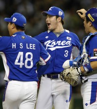 South Korea's closer Lee Hyun-seung (48), first baseman Park Byung-ho (3) and catcher Kang Min-ho celebrate after beating Japan 4-3 in their semifinal game at the Premier12 world baseball tournament at Tokyo Dome in Tokyo, Thursday, Nov. 19, 2015. South Korea advance to the final. (AP Photo/Toru Takahashi)