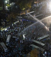 South Korean riot police officers spray water cannons as police officers try to break up protesters trying to march to the Presidential House after a rally against government's policy in Seoul, South Korea, Saturday, Nov. 14, 2015. Police fired tear gas and water cannons Saturday as they clashed with anti-government demonstrators who marched through Seoul in what was believed to be the largest protest in South Korea's capital in more than seven years.(AP Photo/Ahn Young-joon)