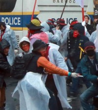 Protesters wearing masks pull ropes to topple a police bus during a rally in Gwanghwamun, central Seoul, on Nov. 14. The ruling Saenuri Party is moving to ban activists from wearing masks to hide their identity. (Yonhap)