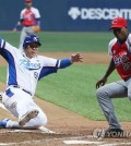Kim Hyun-soo of South Korea (L) scores on a wild pitch by Cuba's Danny Betancourt (R) in the bottom of the fifth inning at Gocheok Sky Dome in Seoul on Nov. 4, 2015. (Yonhap)