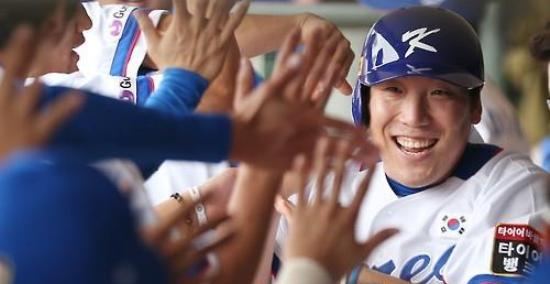 S. Korean OF Kim Hyun-soo, right, is greeted by teammates after scoring. Kim drove in three runs in two straight games. (Yonhap)