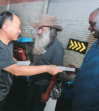 Pastor Shin Suk-geun, left, has begun handing out envelopes containing $5 to the homeless in Downtown Los Angeles as a part of an annual end-of-the-year effort. (Park Sang-hyuk)