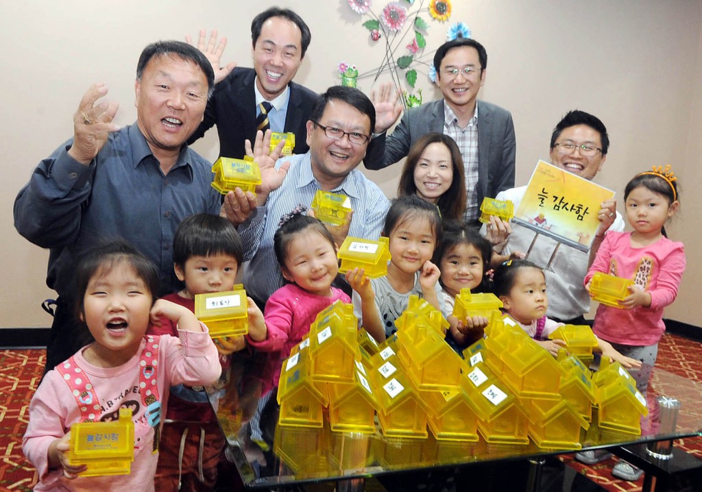 Members of the Oriental Mission Church in Los Angeles with "always thankful" coinbanks (Park Sang-hyuk/Korea Times)