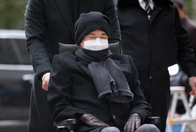 Lee Jae-hyun, the chairman of food and entertainment conglomerate CJ Group, in a wheelchair, is moved into a courtroom at the Seoul High Court, southern Seoul, on Dec. 15, 2015. (Yonhap) 