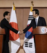 South Korean Foreign Minister Yun Byung-se, right, shakes hands with his Japanese counterpart Fumio Kishida after their joint press conference at Foreign Ministry in Seoul, South Korea, Monday, Dec. 28, 2015. The foreign ministers said they had reached a deal meant to resolve a decades-long impasse over Korean women forced into Japanese military-run brothels during World War II, a potentially dramatic breakthrough between the Northeast Asian neighbors and rivals. (AP Photo/Ahn Young-joon)