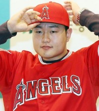 New Los Angeles Angels infielder Choi Ji-man wears his jersey in Incheon, west of Seoul, on Dec. 23, 2015. Choi was selected by the Major League Baseball club at the annual Rule 5 Draft in Nashville, Tennessee, on Dec. 10, the final day of the MLB Winter Meetings. (Yonhap)