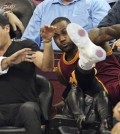 Cleveland Cavaliers' LeBron James falls into Ellie Day, wife of PGA Tour golf player Jason Day, at left, during the second half of an NBA basketball game against the Oklahoma City Thunder, Thursday, Dec. 17, 2015, in Cleveland. (John Kuntz/The Plain Dealer via AP)