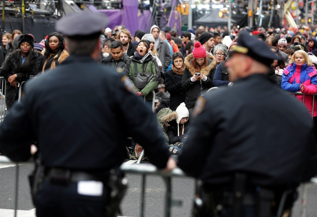 Police officers look over a crowd waiting for midnight in Times Square in New York, Thursday, Dec. 31, 2015. Around 1 million people are expected to converge on Times Square for the annual New Year's Eve celebration. This year's festivities will also be attended by nearly 6,000 New York City police officers, including members of a specialized counterterrorism unit. (AP Photo/Seth Wenig)