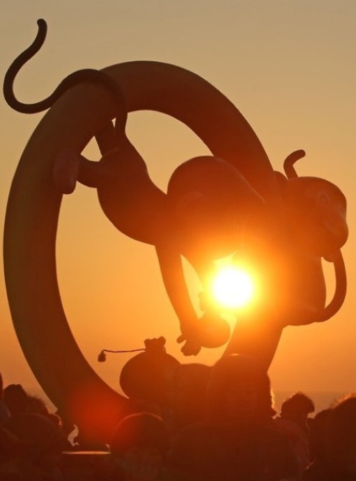 The sun rises over a sculpture of baby monkeys on Ganjeol Cape, a coastal point where a sunrise can be viewed earliest on the Korean Peninsula, on the coast of Ulsan in southeastern South Korea on Jan. 1, 2016, as visitors gather around the monument to view the New Year's first sunrise and make their New Year's wishes. The monument was set up to celebrate the new year, which falls on the year of the monkey in the Oriental zodiac. (Yonhap) 