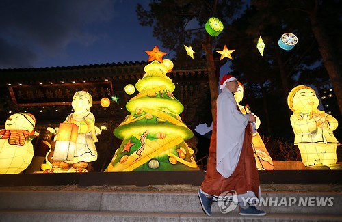 A monk wearing a Santa hat walks past Christmas lights and decorations set up at the Jogye Temple in Seoul on Dec. 16, 2015. The temple is of the Jogye Order, the largest Buddhist sect in the country. (Yonhap) 