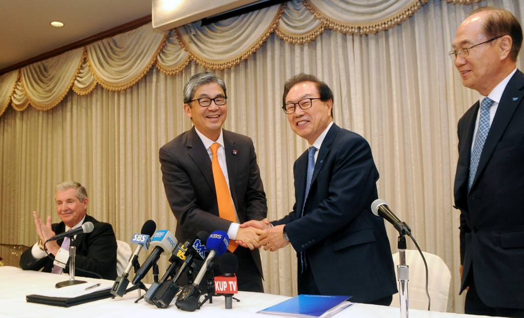 BBCN CEO Kevin Kim, second from left, shakes hands with Wilshire Chairman Koh Suk-hwa, right, during an official announcement of the two banks' merger inside Oxford Palace Hotel in Los Angeles' Koreatown Monday. (Park Sang-hyuk/Korea Times)