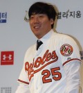 Kim Hyun-soo, an outfielder who is moving on to the Baltimore Orioles, poses in his new team's uniform at a news conference in Seoul on Dec. 29, 2015. Kim, 27, signed a two-year contract amounting to US$7 million with the major league team and became the first South Korean player to jump from the Korea Baseball Organization to the Major League Baseball via free agency. (Yonhap)