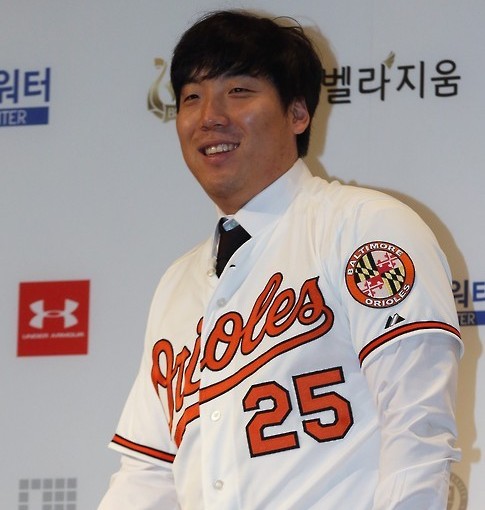Kim Hyun-soo, an outfielder who is moving on to the Baltimore Orioles, poses in his new team's uniform at a news conference in Seoul on Dec. 29, 2015. Kim, 27, signed a two-year contract amounting to US$7 million with the major league team and became the first South Korean player to jump from the Korea Baseball Organization to the Major League Baseball via free agency. (Yonhap) 