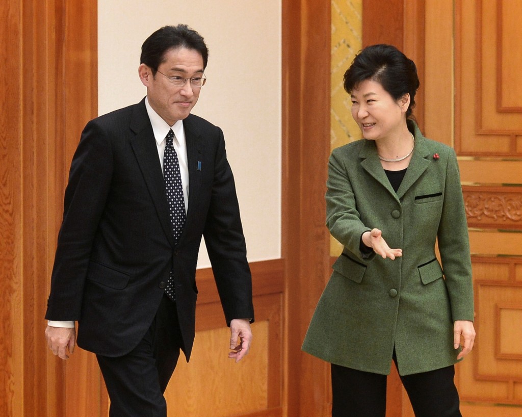 Japanese Foreign Minister Fumio Kishida, left, is shown the way by South Korean President Park Geun-hye prior to a meeting at the presidential house in Seoul, South Korea, Monday, Dec. 28, 2015. The foreign ministers of South Korea and Japan said Monday they had reached a deal meant to resolve a decades-long impasse over Korean women forced into Japanese military-run brothels during World War II, a potentially dramatic breakthrough between the Northeast Asian neighbors and rivals. (Chun Jean-hwan/Newsis via AP) 