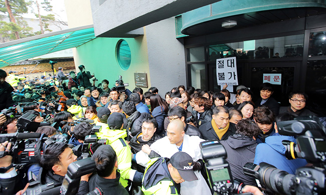 Police officers try to forcibly remove temple officials from the entrance of a building on the grounds of Jogye Temple in central Seoul, Wednesday, where Korean Confederation of Trade Unions (KCTU) head Han Sang-gyun has taken refuge to avoid arrest. (Yonhap)