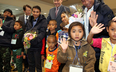 Refugees from Myanmar wave to reporters as they arrive at Incheon International Airport on Dec. 22, 2015 for resettlement. (Yonhap)