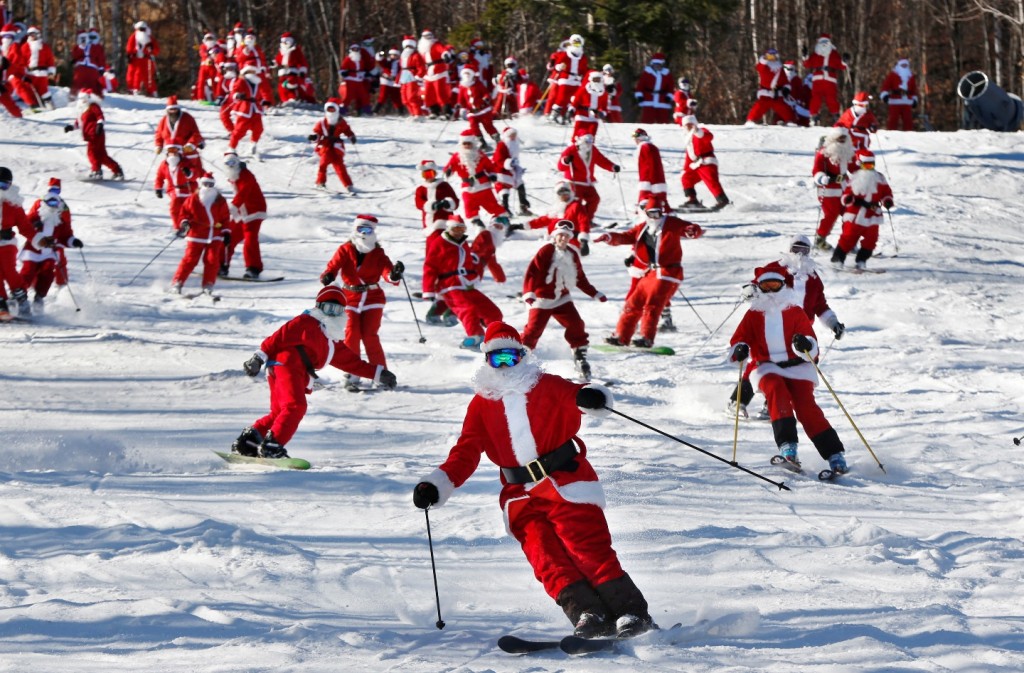 Skiers and snowboarders dressed as Santa take a run en masse at the Sunday River ski resort, Sunday, Dec. 6, 2015, in Newry, Maine. Skiers with full Santa outfits got free lift tickets for donating $15 to the Sunday River Community Fund. (AP Photo/Robert F. Bukaty)