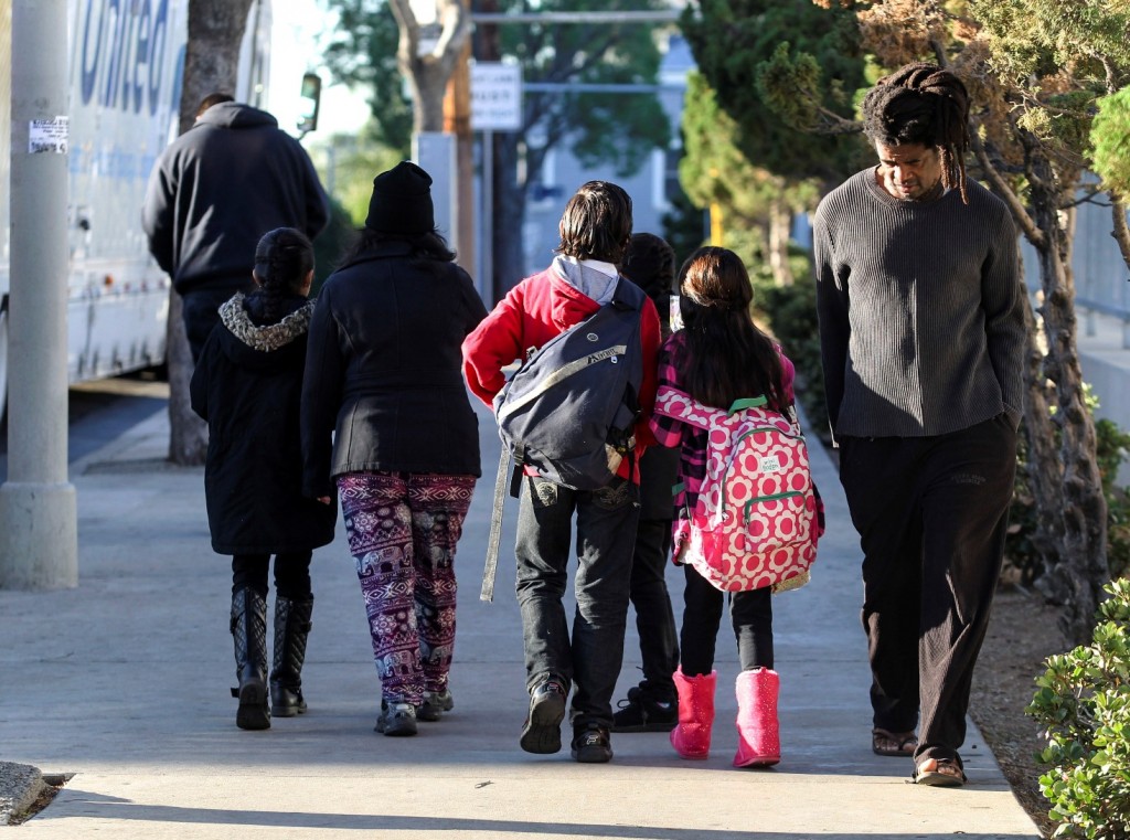 Parents take their children return home from school early Tuesday, Dec. 15, 2015, in Los Angeles. All schools in the vast Los Angeles Unified School District, the nation's second largest, have been ordered closed due to an electronic threat Tuesday. (AP Photo/Ringo H.W. Chiu)