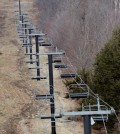 A chairlift sits idle at Oak Mountain Ski Center on Tuesday, Dec. 8, 2015, in Speculator, N.Y. Some Northeasterners are beginning to wonder if a white Christmas may just be a dream, and business owners who rely on snow are starting to worry if warm weather could lead to a nightmare winter. (AP Photo/Mike Groll)