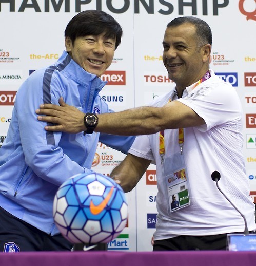 Shin Tae-yong (L), coach of South Korea's under-23 football team, and Jamal Abu Abed, coach of Jordan's under-23 team, shake hands during a press conference in Doha on Jan. 22, 2016, a day before their teams meet in the quarterfinals of the Asian U-23 Championships. (Yonhap)