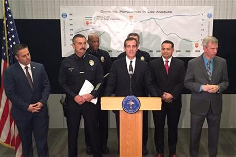Los Angeles Mayor Eric Garcetti, center at podium, and police chief Charlie Beck, center left, are among officials reporting about crime in the city at a downtown news conference Wednesday, Jan. 13, 2016. Although crimes including murder and rape are up across the board in Los Angeles, the city is still far less violent than it has been in the past, city leaders said, as they released citywide statistics for 2015. (AP Photo/Amanda Myers)