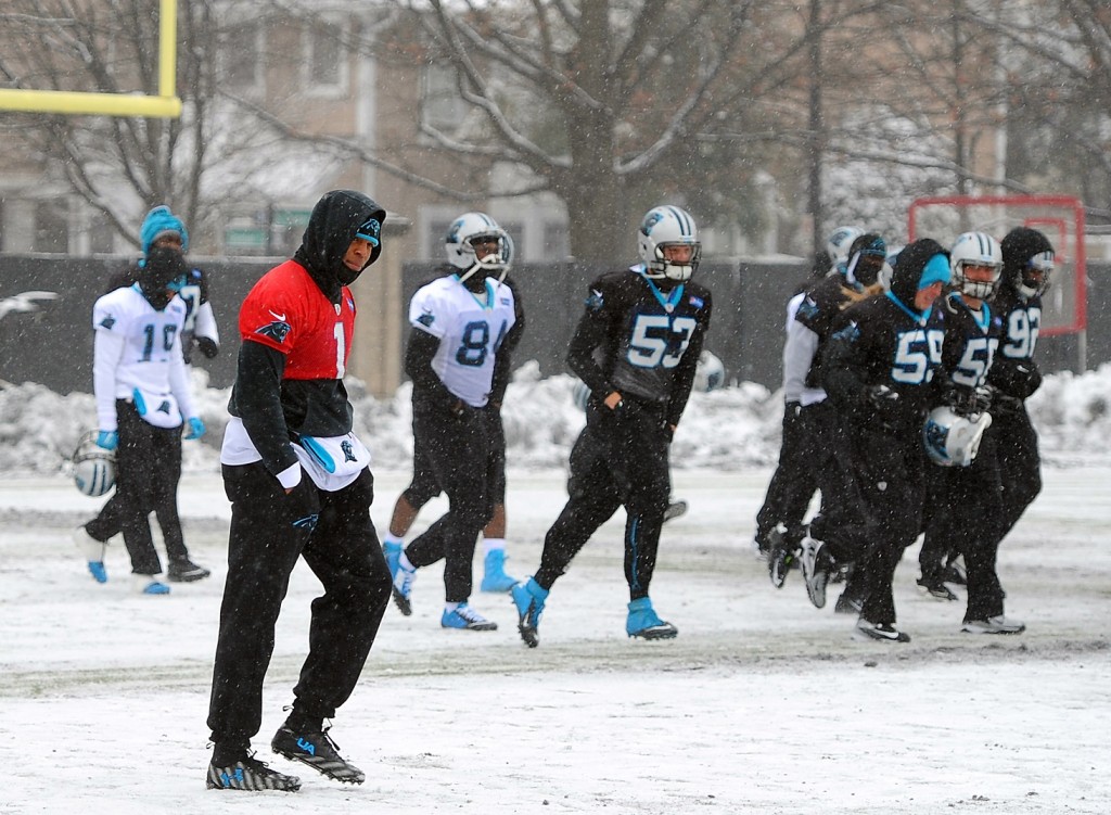 Carolina Panthers quarterback Cam Newton, left, walks across a practice field covered in snow and ice, Friday, Jan. 22, 2016, in Charlotte, N.C. The Panthers host the Arizona Cardinals in the NFC championship NFL football game on Sunday. (Jeff Siner/The Charlotte Observer via AP)
