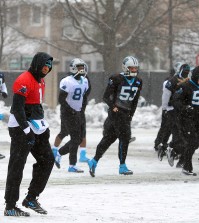 Carolina Panthers quarterback Cam Newton, left, walks across a practice field covered in snow and ice, Friday, Jan. 22, 2016, in Charlotte, N.C. The Panthers host the Arizona Cardinals in the NFC championship NFL football game on Sunday. (Jeff Siner/The Charlotte Observer via AP)