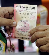 A clerk hands over a Powerball ticket to a customer, Wednesday, Jan. 6, 2016, at a local grocery store in Hialeah, Fla. The estimated Powerball jackpot for Wednesday night has soared to $500 million. The last time Powerball had grown this large was in February 2015, when three winners split a $564.1 million prize. (AP Photo/Alan Diaz)
