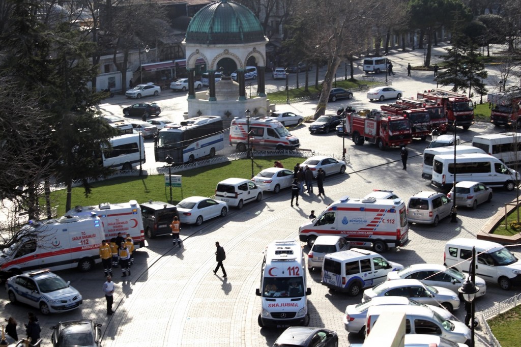 Ambulances and firefighters stationed near the city's landmark Sultan Ahmed Mosque or Blue Mosque after an explosion at Istanbul's historic Sultanahmet district, which is popular with tourists, Tuesday, Jan. 12, 2016. The Istanbul governor's office says the explosion at the city's historic Sultanahmet district has killed least 10 people. A statement says 15 other people were injured in Tuesday's blast. The cause of the explosion is under investigation, but state-run TRT television says it was likely caused by a suicide bomber. The monument in the background is "German Fountain." (IHA via AP) TURKEY OUT