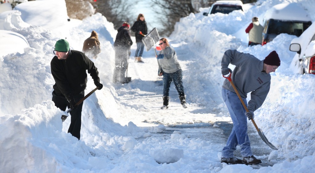 Residents of W. Leicester St. in Winchester, Va. join forces to shovel out on Sunday, Jan. 24, 2016, after an historic snowstorm dumped more than 30 inches of snow on the city Friday night and Saturday. (Jeff Taylor/The Winchester Star via AP)