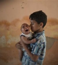 FILE - In this Dec. 23, 2015, file photo, 10-year-old Elison nurses his 2-month-old brother Jose Wesley, who was born with microcephaly, at their house in Poco Fundo, Pernambuco state, Brazil. The U.S. Centers for Disease Control and Prevention said Wednesday, Jan. 13, 2016, that it has found the strongest evidence so far of a possible link between a mosquito-borne virus and a surge of birth defects in Brazil. (AP Photo/Felipe Dana, File)