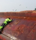 A Coast Guard rescuer tries to enter a capsized Chinese fishing boat off South Korea's southwestern coast on Jan. 27, 2016, to save crew members trapped inside. The vessel overturned hile it was being towed by another Chinese fishing boat. There were 10 fishermen aboard the boat. (Photo courtesy of West Sea Fisheries Management Service) (Yonhap)