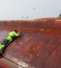 A Coast Guard rescuer tries to enter a capsized Chinese fishing boat off South Korea's southwestern coast on Jan. 27, 2016, to save crew members trapped inside. The vessel overturned hile it was being towed by another Chinese fishing boat. There were 10 fishermen aboard the boat. (Photo courtesy of West Sea Fisheries Management Service) (Yonhap)