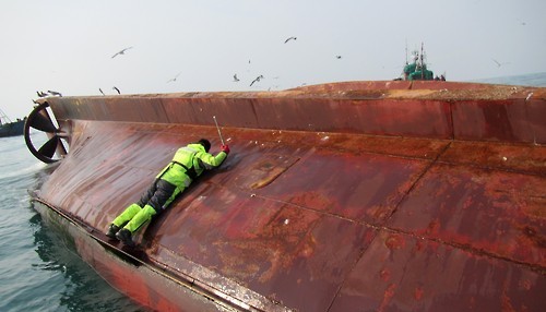 A Coast Guard rescuer tries to enter a capsized Chinese fishing boat off South Korea's southwestern coast on Jan. 27, 2016, to save crew members trapped inside. The vessel overturned hile it was being towed by another Chinese fishing boat. There were 10 fishermen aboard the boat. (Photo courtesy of West Sea Fisheries Management Service) (Yonhap) 