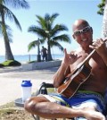 In this photo taken Tuesday Jan. 26, 2016, Kent Terada shows the shaka or "hang loose" sign while sitting at Ala Moana Beach Park in Honolulu. A new study looking at the five elements of a well ordered life, such as financial security, sense of community and purpose, ranks Hawaii just ahead of Alaska. (AP Photo/Audrey McAvoy)