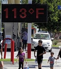 FILE - Pedestrians walk past a digital thermometer reading 113 degrees Fahrenheit in the Canoga Park section of Los Angeles on Saturday, Aug. 15, 2015. The National Weather Service issued warnings of excessive heat throughout Southern California into Saturday night, with some areas expected to see highs of 10 to 15 degrees above normal. (AP Photo/Richard Vogel)