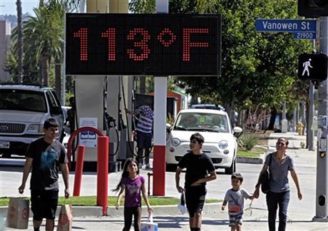 FILE - Pedestrians walk past a digital thermometer reading 113 degrees Fahrenheit in the Canoga Park section of Los Angeles on Saturday, Aug. 15, 2015. The National Weather Service issued warnings of excessive heat throughout Southern California into Saturday night, with some areas expected to see highs of 10 to 15 degrees above normal. (AP Photo/Richard Vogel) 