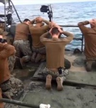 This picture released by the Iranian state-run IRIB News Agency on Wednesday, Jan. 13, 2016, shows detention of American Navy sailors by the Iranian Revolutionary Guards in the Persian Gulf, Iran. Iranian state television is reporting that all 10 U.S. sailors detained by Iran after entering its territorial waters have been released. Iran's Revolutionary Guard said the sailors were released Wednesday after it was determined that their entry was not intentional. The nine men and one woman were being held at an Iranian base on Farsi Island in the Persian Gulf after being detained nearby on Tuesday.(Sepahnews via AP)