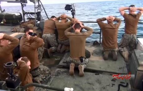 This picture released by the Iranian state-run IRIB News Agency on Wednesday, Jan. 13, 2016, shows detention of American Navy sailors by the Iranian Revolutionary Guards in the Persian Gulf, Iran. Iranian state television is reporting that all 10 U.S. sailors detained by Iran after entering its territorial waters have been released. Iran's Revolutionary Guard said the sailors were released Wednesday after it was determined that their entry was not intentional. The nine men and one woman were being held at an Iranian base on Farsi Island in the Persian Gulf after being detained nearby on Tuesday.(Sepahnews via AP)