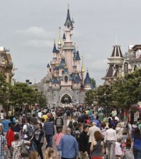 FILE - This Tuesday, May 12, 2015 file photo shows visitors walking toward the Sleeping Beauty's Castle, background, at Disneyland Paris in Marne la Vallee, east of Paris, France. A French police official says a man found to be carrying two handguns has been arrested at a hotel at Disneyland Paris. France remains under a state of emergency since Nov. 13 Islamic extremist attacks around Paris that killed 130 people. (AP Photo/Michel Euler, File)