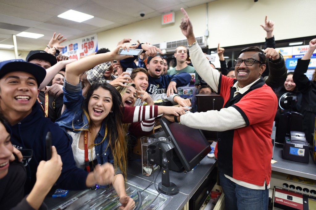 7-Eleven store clerk M. Faroqui celebrates with customers after learning the store sold a winning Powerball ticket on Wednesday, Jan. 13, 2016 in Chino Hills, Calif. One winning ticket was sold at the store located in suburban Los Angeles said Alex Traverso, a spokesman for California lottery. The identity of the winner is not yet known. (Will Lester/The Sun via AP) 