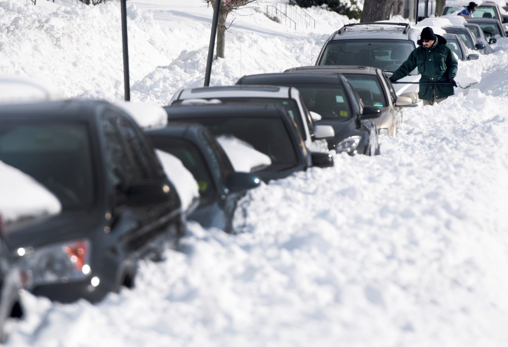 Ragi Puthur digs his car out from snow outside his home in Towson, Md., Monday, Jan. 25, 2016. East Coast residents continued to dig themselves out after a massive weekend snowstorm. (AP Photo/Steve Ruark)