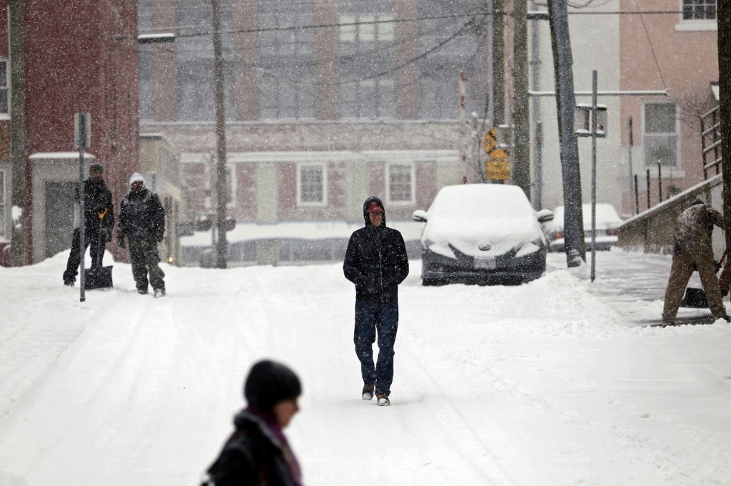 Pedestrians walk along First Street South as snow falls, Friday, Jan. 22, 2016, in Charlottesville, Va.  (Ryan M. Kelly/The Daily Progress via AP)  