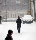 Pedestrians walk along First Street South as snow falls, Friday, Jan. 22, 2016, in Charlottesville, Va.  (Ryan M. Kelly/The Daily Progress via AP)